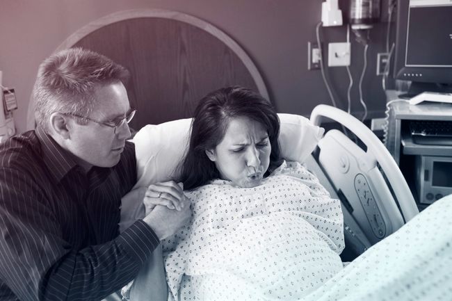 Man watching wife giving birth in hospital