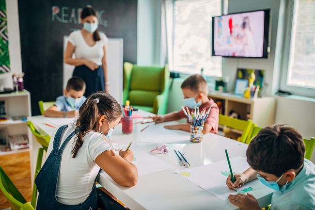 An image of kids in a classroom wearing masks.