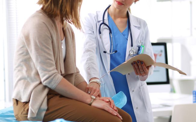 Doctor Talking to Patient Sitting on Table