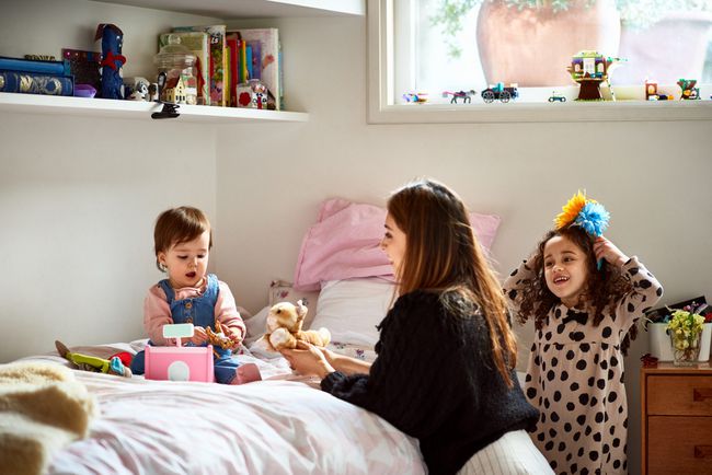 An image of a mother playing with her two daughters.