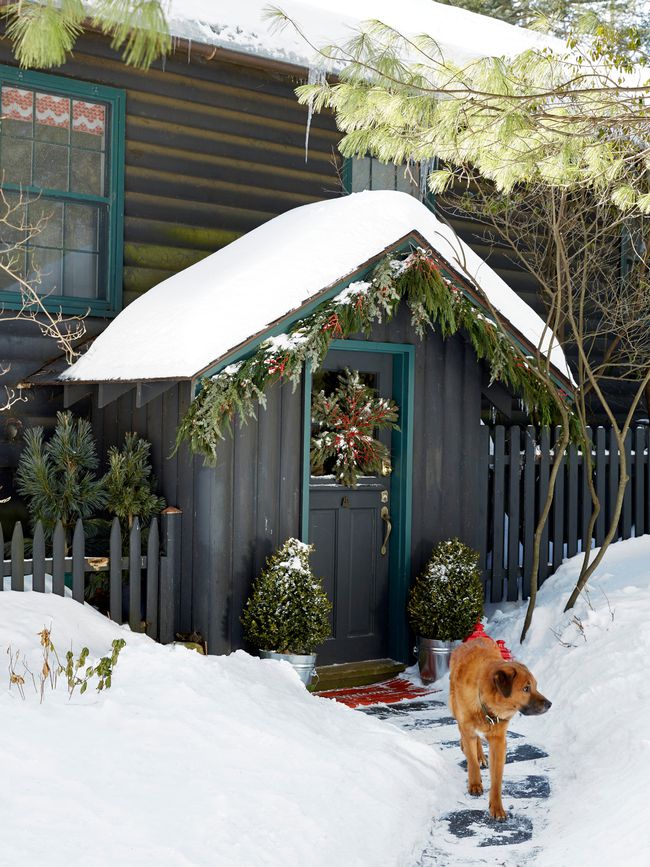 snow covered winter cabin with dog