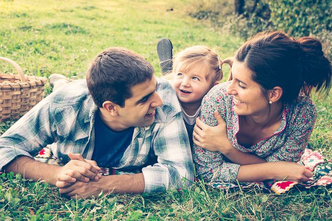 happy couple and toddler having a picnic