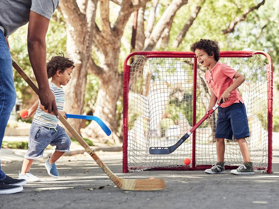 Father and Sons Playing Street Hockey