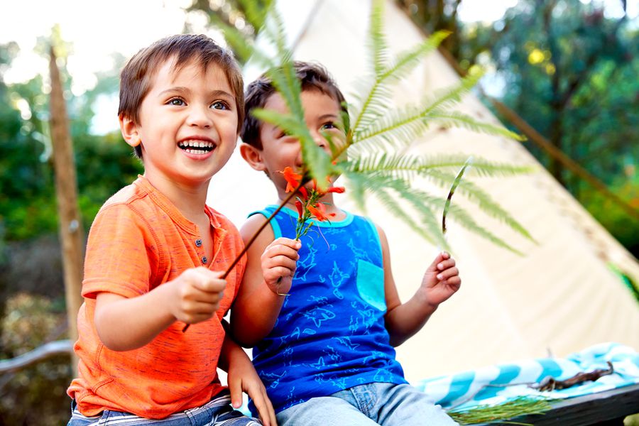 Two children with branches and flowers