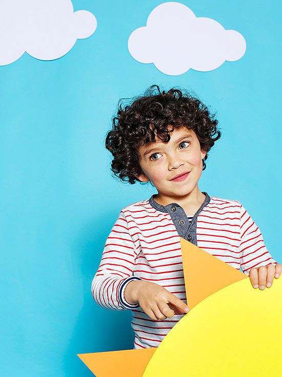 Boy holding large paper sun