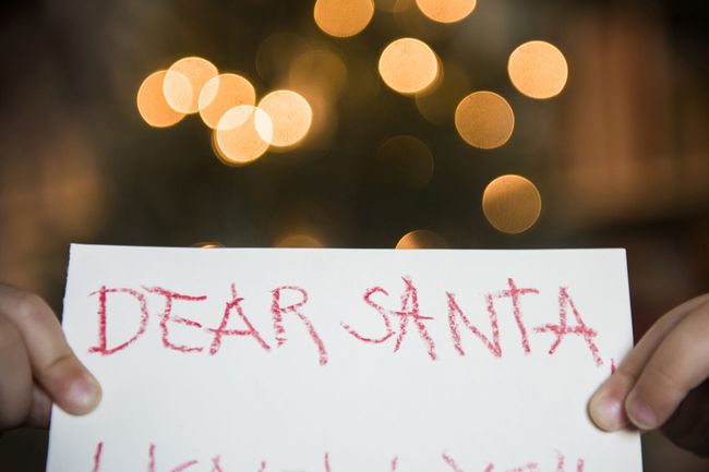 An image of a child holding a dear Santa letter.