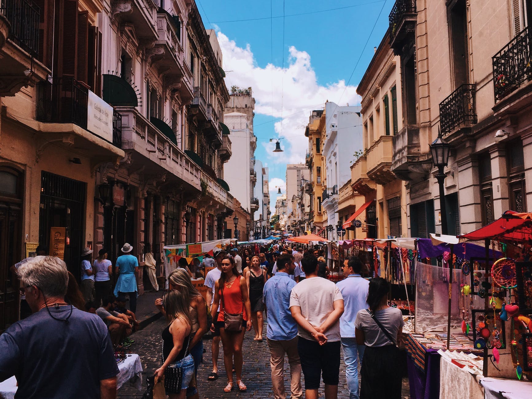 people standing on road beside market and high rise buildings - tips for planning a trip to Buenos Aires, Argentina, from Wanderful.