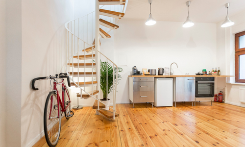 The inside of an apartment with a small kitchen and staircase