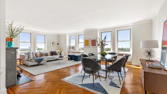 A bright living room and dining room staged with mid-century furnishings