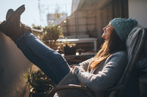 Woman relaxing on balcony on cool day